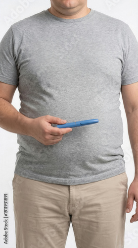 Overweight man holding GLP-1 injection pen against abdomen, representing medical weight loss treatment and diabetes management concept.
