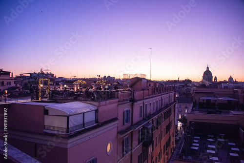 Tablou pe pânză Rome at dusk, where the sky melts from gold to rose to deep violet, and every rooftop catches fire for a moment before the night gently steals the light