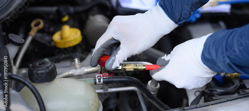 Cuadro en lienzo The focus is on the technician's hands inspecting the car's air conditioning system and sizing the equipment for refilling the refrigerant in the car's AC system