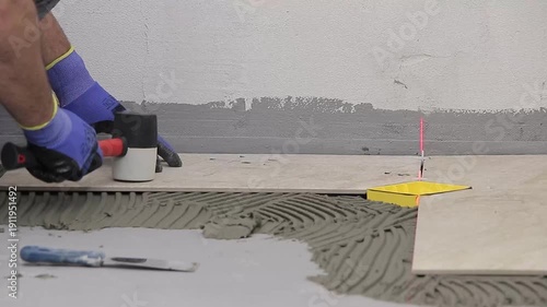 Close Up of Worker Installing Ceramic Floor Tiles