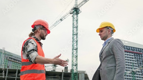 Fotografija General contractor greeting subcontractor on building site