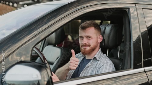 Male driver sitting in the car and showing thumbs up. Slow motion