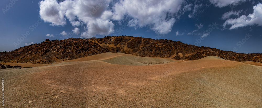 Fototapeta premium Tenerife, Canary Islands, Spain: red mountains, rock formations and rainbow sand dunes hiking in the Teide National Park with Mount Teide (Pico del Teide) on the background, spectacular landscape