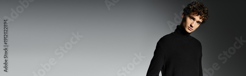 Young handsome man showcasing modern fashion with flair and confidence in a minimalist setting