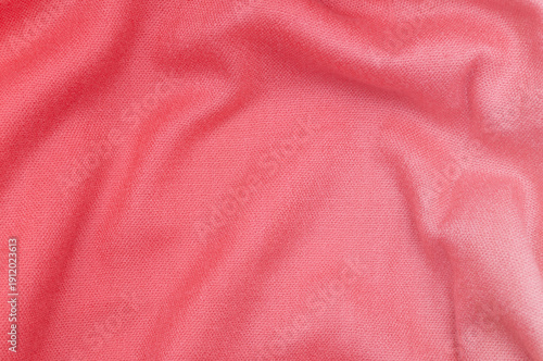 A bright pink fabric with soft folds. A soft knit surface with a distinctive weave.