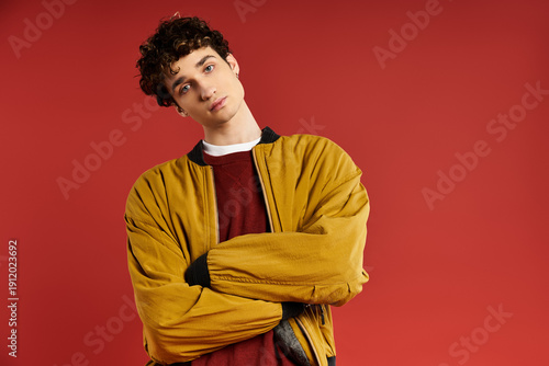 Εκτύπωση καμβά Stylish young man embodies modern fashion against a vibrant red background