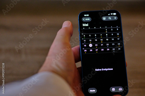 Handy Iphone in der Hand mit Kalender 