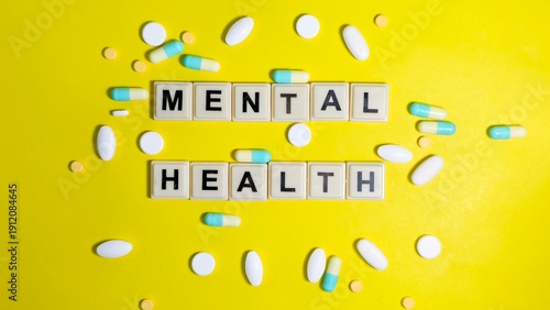 Canvastavla Letter tiles spelling MENTAL HEALTH are surrounded by various pills and capsules on a bright yellow background, highlighting the intersection of psychiatric care, medication, and wellness