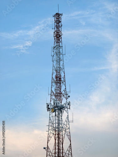Telecommunication Tower with Antennas Against Blue Sky Background