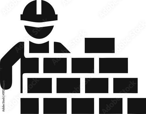 Professional construction worker wearing a hard hat stands behind a sturdy brick wall