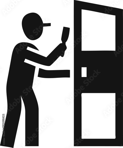 Skilled person in a cap painting a door, performing home renovation or maintenance work
