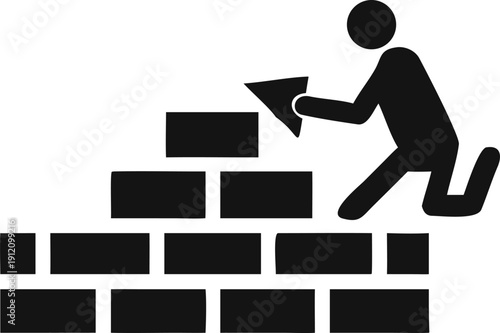 Worker kneeling while carefully placing a new brick onto a growing wall