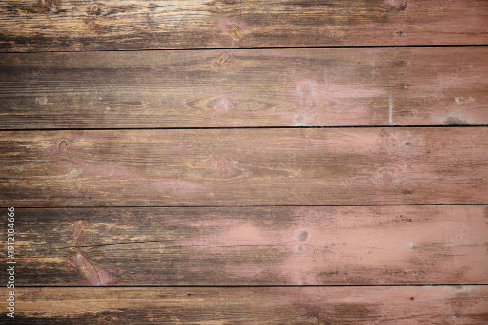 Obraz premium A top-down view of horizontal aged wooden boards with a natural grainy texture, knots, and remnants of old reddish-brown paint. Perfect for rustic backdrops, vintage designs, or food photography surfa