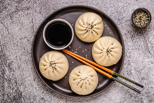 Steamed buns with savory filling served on a black plate