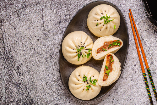 Fotografía Steamed buns on a dark plate.