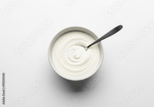 Bowlofyogurtwithspoonisolatedonwhitesurface