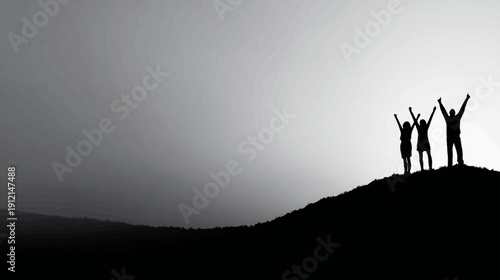 Silhouettes of joyful people raising arms in triumph on a mountain hilltop against a monochrome sky, celebrating freedom and success.