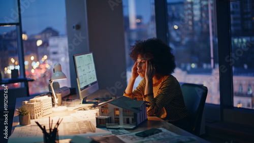 Tired architect sitting dark workplace massaging temples closeup. Fatigued woman
