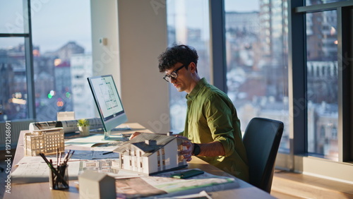 Architect checking house layout working on architectural project at office. 