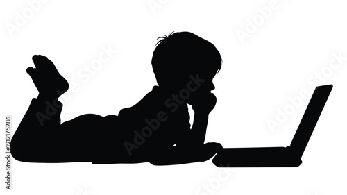 Child using a laptop computer on the floor a dark silhouette