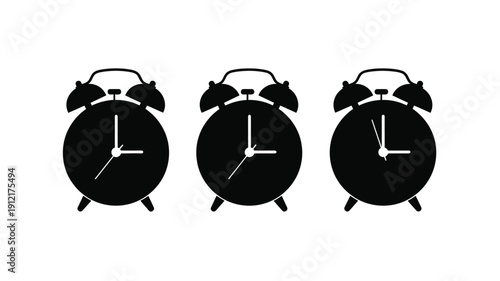Three black alarm clocks showing different times a stark silhouette