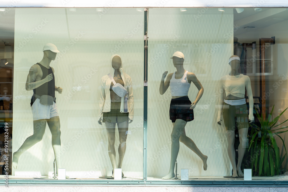 Fototapeta premium Athletic Clothing Store Window Featuring Mannequins in Modern Fitness Outfits Neutral Colors