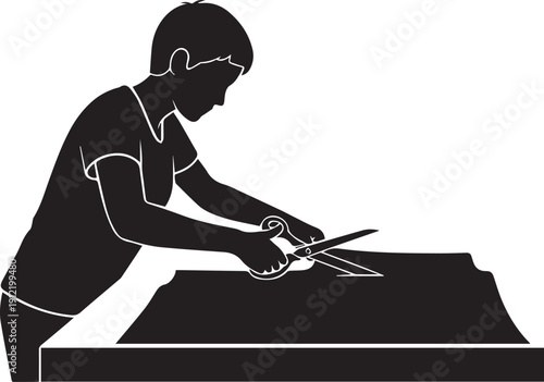 Silhouette of a person using scissors on a rectangular surface