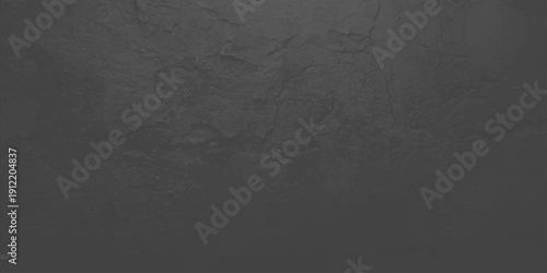 A dark and aged black and white grunge background featuring a rough textured stone surface with a vintage gray concrete wall pattern for a blank dirty backdrop design