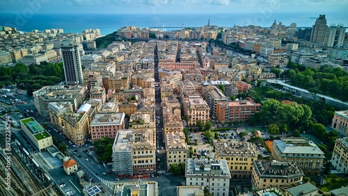 Aerial drone view looking down a central street in Genoa, Italy, towards the Ligurian Sea
