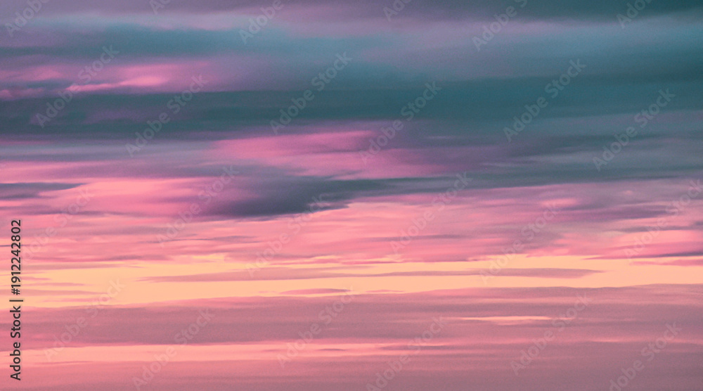 Fototapeta premium Vibrant magenta and cyan sunset sky with soft cloud layers