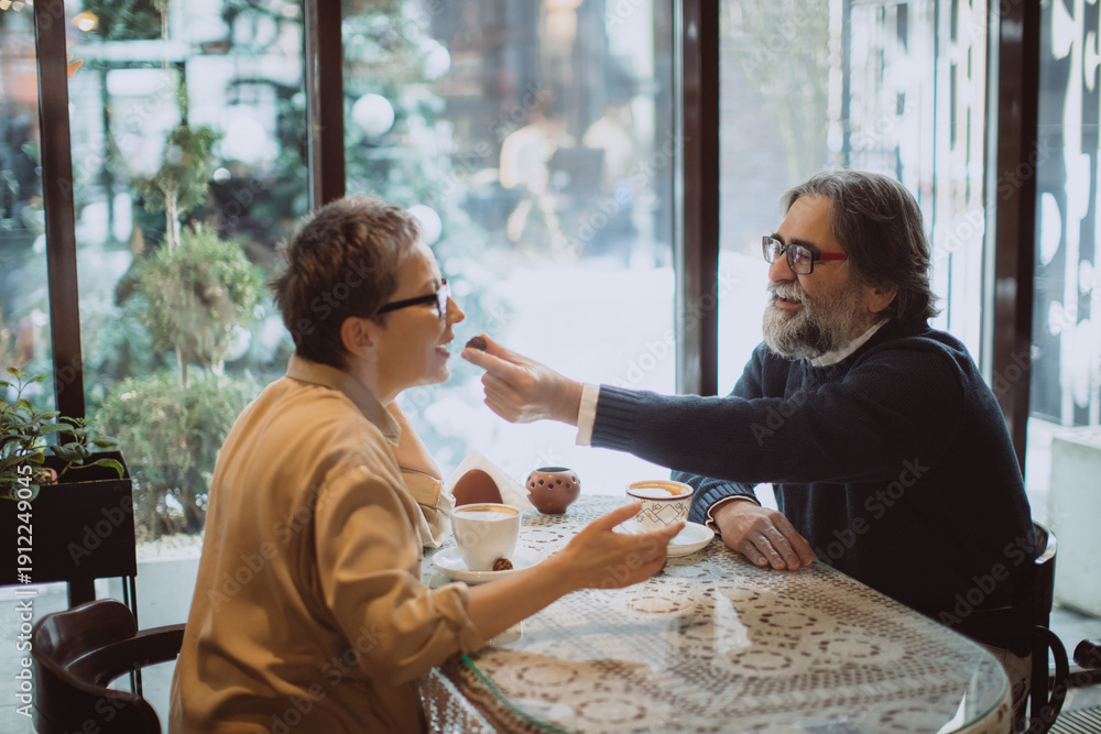 Obraz premium Senior couple sharing dessert in a cafe
