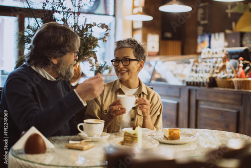 Slika na platnu Mature couple enjoying coffee and cakes at cafe