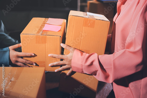 Slika na platnu Startup SME small business entrepreneur of freelance Asian woman wearing apron using laptop and box to receive and review orders online to prepare to pack sell to customers, online sme business ideas