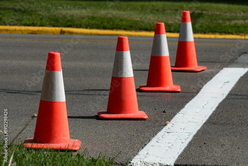 Orange and white safety cones lining a crosswalk with a shallow depth of field and copy space