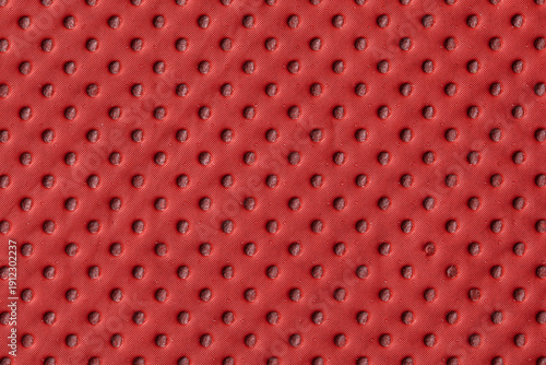 Close-up of red textured surface with raised circular bumps.
Industrial red surface featuring uniform dotted texture.