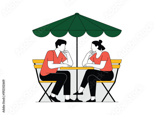 A man and woman sit at a table under a green umbrella, engaged in conversation.