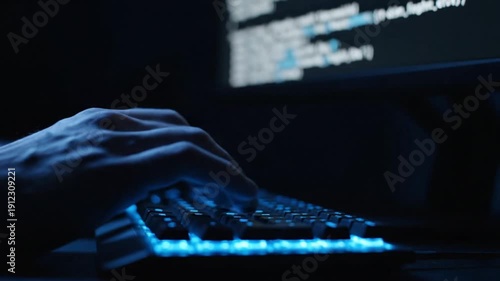 Close up of hands typing on a glowing blue keyboard in a dark room, coding and hacking concept