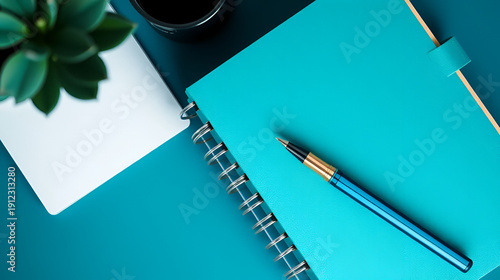 A photo of a teal blue journal with a pen, an elegant notebook or planner, shot from above with copy space