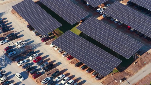 Photovoltaic canopy over parking area producing renewable electricity. Solar panels provide shade for vehicles while generating sustainable energy integrated into city infrastructure.