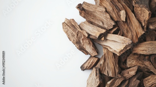 Aromatic oud wood chips piled against a clean white background for luxurious fragrance marketing