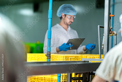 An inspector ensures food quality for the global supply chain. This smart factory uses AI and sustainable ESG practices for efficient, traceable food distribution.