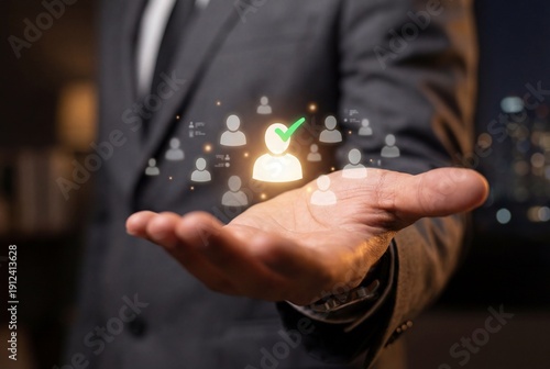 Businessman selecting top candidate from virtual group of glowing user icons with green check mark