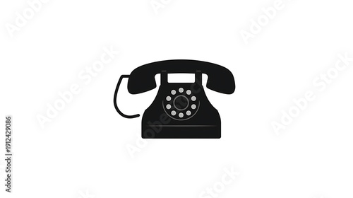 Vintage rotary telephone resting against a plain background
