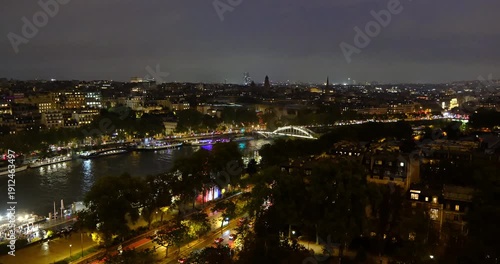 High angle view of Seine River at rainy night with illuminated riverbank and Debilly Footbridge in Paris, France