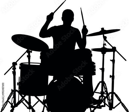 Silhouette of a drummer playing a drum set with sticks