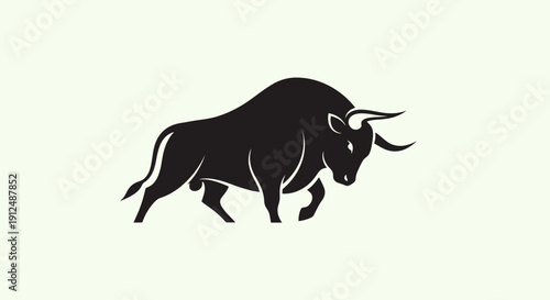 Silhouette of a powerful charging bull in profile view.