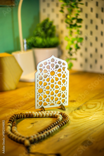Elegant wooden Islamic geometric star pattern ornament on a wooden desk, blurred background with plant, perfect for Ramadan and Eid decoration