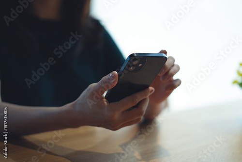Closeup, woman using mobile phone for online shopping via mobile app at coffee shop. 