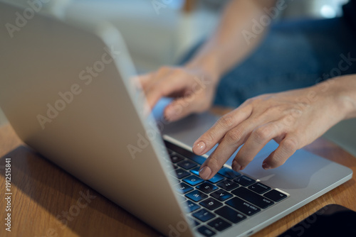 Fotografija Close up of casual business woman hands typing on laptop computer on table, sear