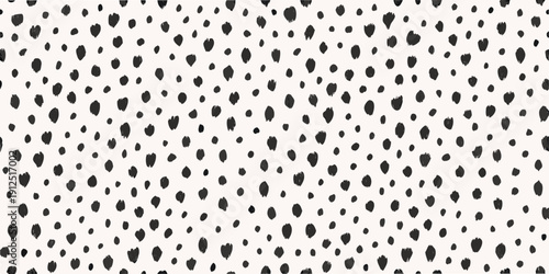 Abstract background of scattered irregular black shapes on a white surface